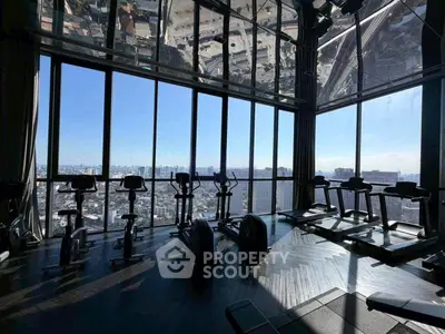 Luxurious high-rise gym with panoramic city views and modern fitness equipment.