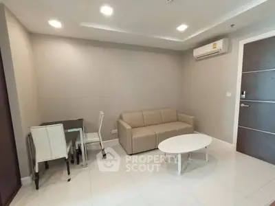 Modern living room with beige sofa, dining table, and air conditioning in a stylish apartment.