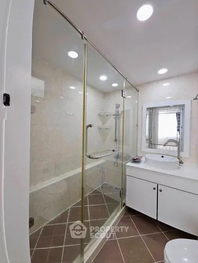 Modern bathroom with glass shower enclosure and sleek vanity in a contemporary home.