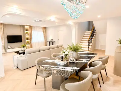 Luxurious open-plan living and dining area with elegant decor and modern lighting