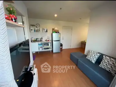 Modern living room with sleek furniture and open kitchen layout in a cozy apartment.