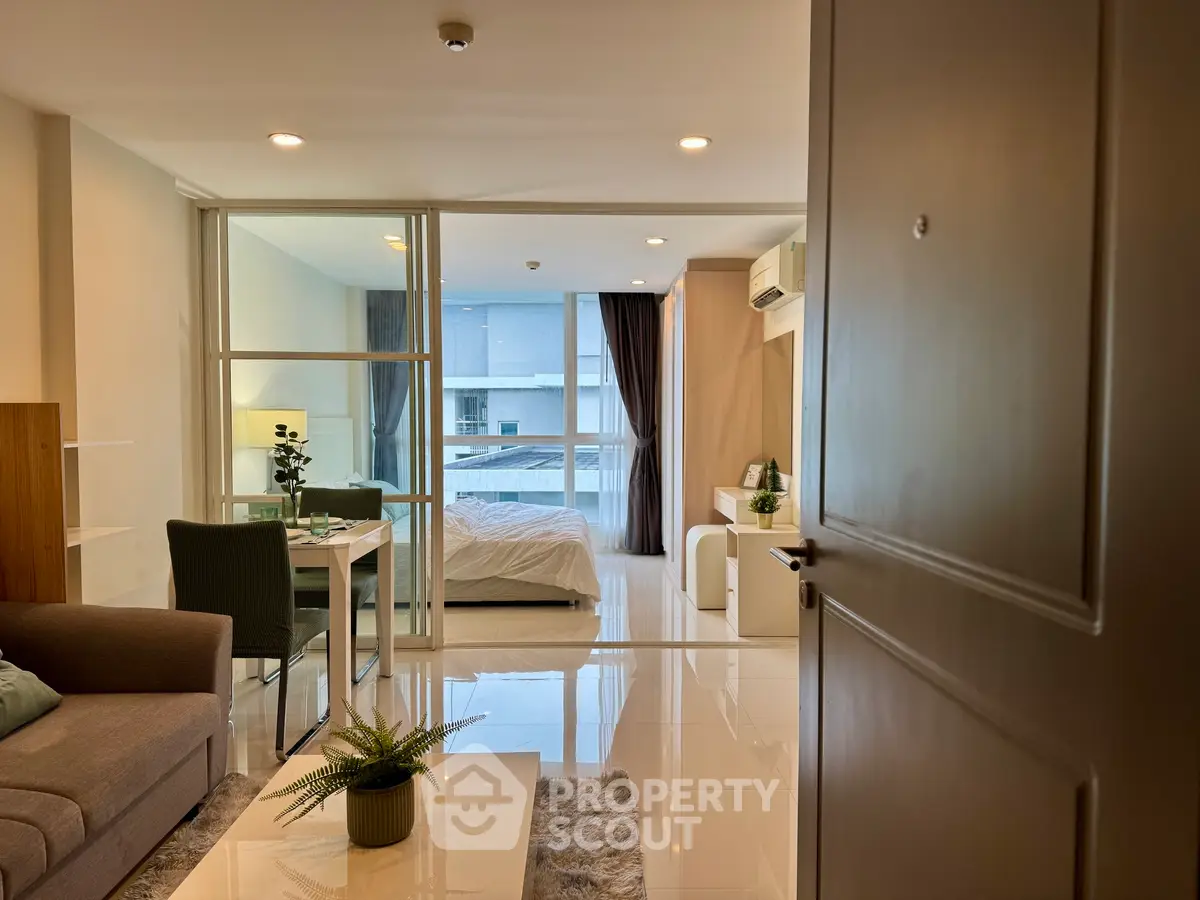 Modern open-plan living room with cozy bedroom and sleek decor