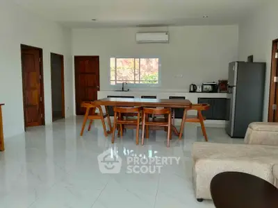 Spacious open-layout kitchen and dining area with modern appliances and elegant furniture.