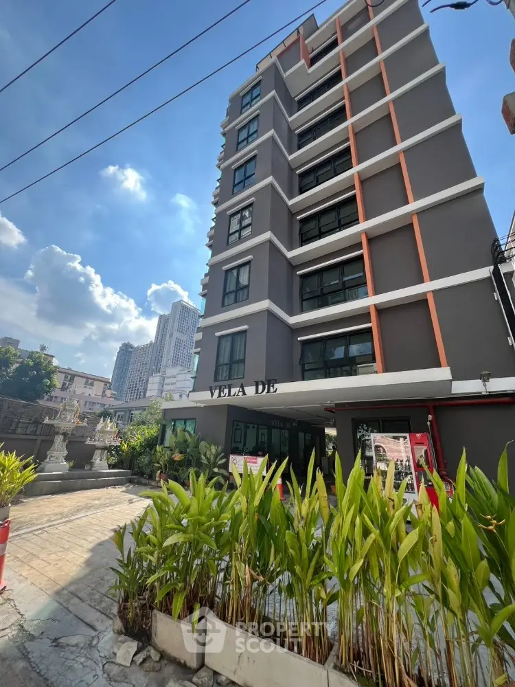 Modern urban apartment building with lush greenery and city skyline view