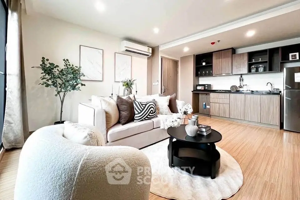 Modern open-layout living room with stylish kitchen, cozy seating, and elegant decor.