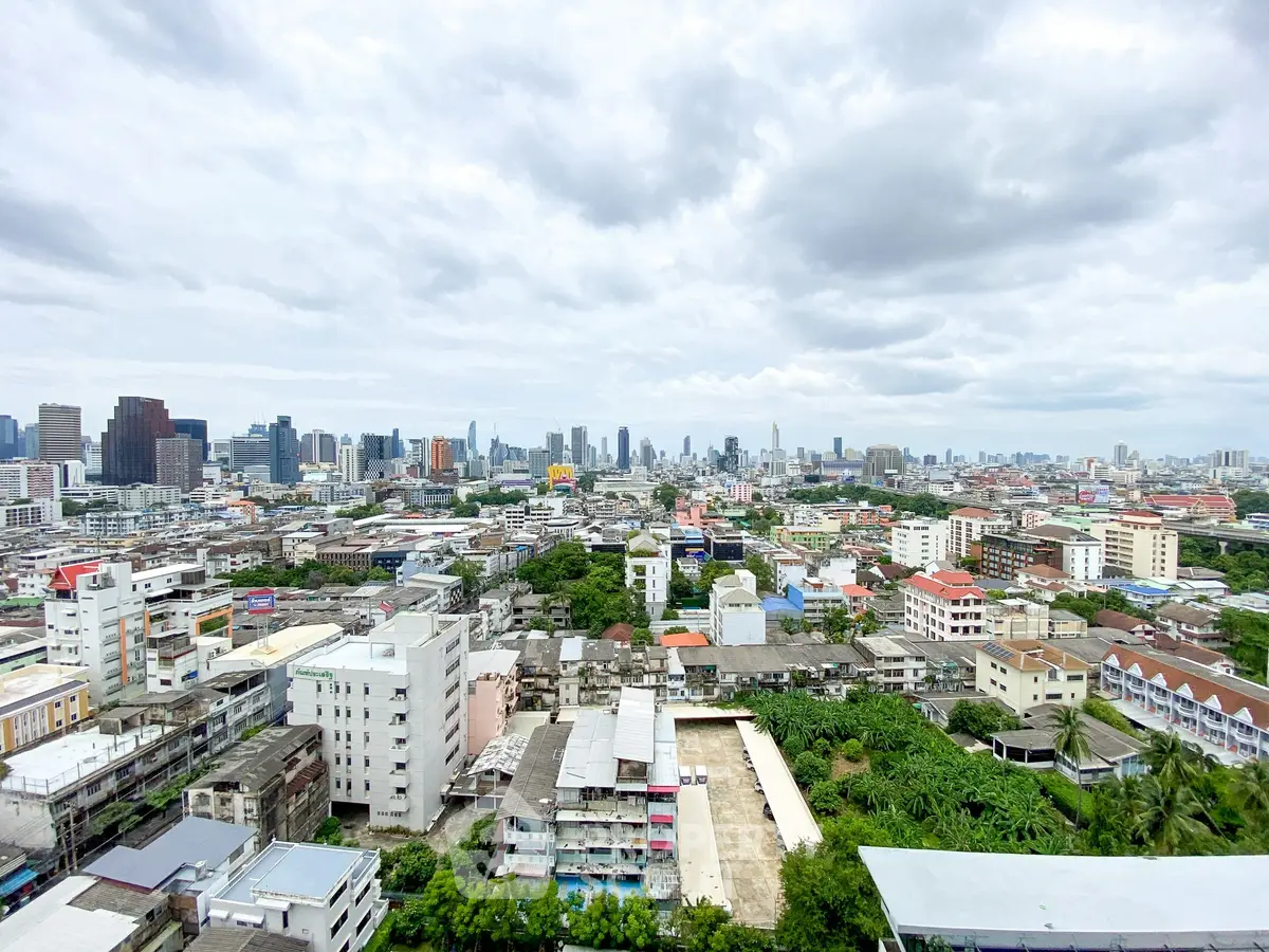 Stunning cityscape view showcasing urban skyline and residential buildings under a cloudy sky.