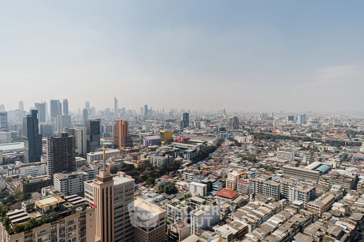 Stunning panoramic cityscape view showcasing urban skyline and high-rise buildings under a clear blue sky.