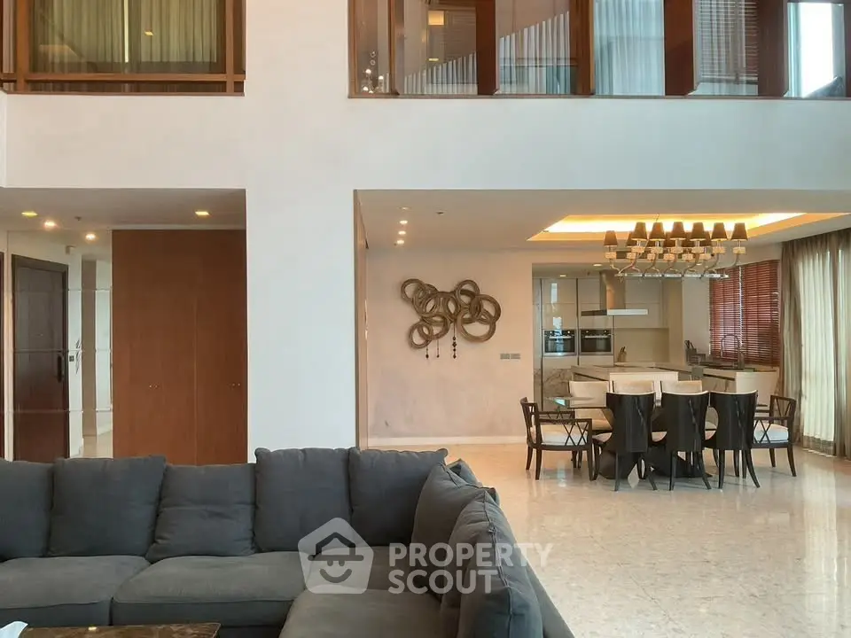 Luxurious open-plan living and dining area with modern decor and elegant lighting.