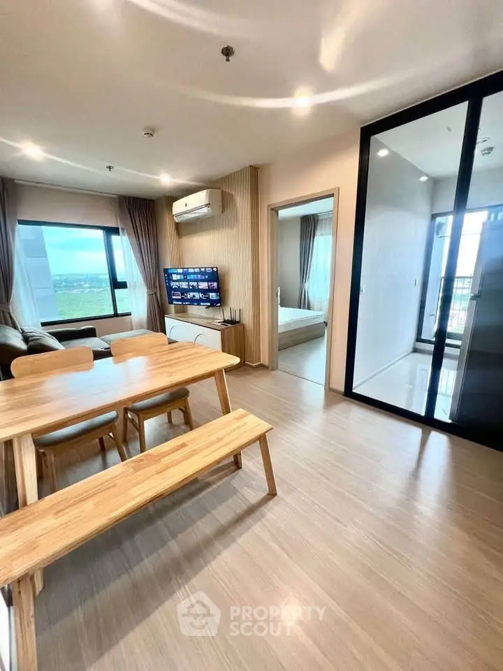Modern open-plan living room with dining area and large windows offering scenic views.
