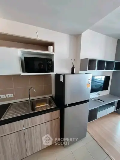Modern kitchen with sleek appliances and stylish cabinetry in a contemporary apartment.