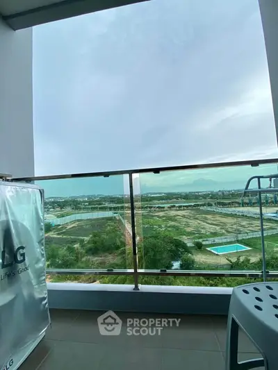 Spacious balcony with stunning panoramic view of lush greenery and distant cityscape.