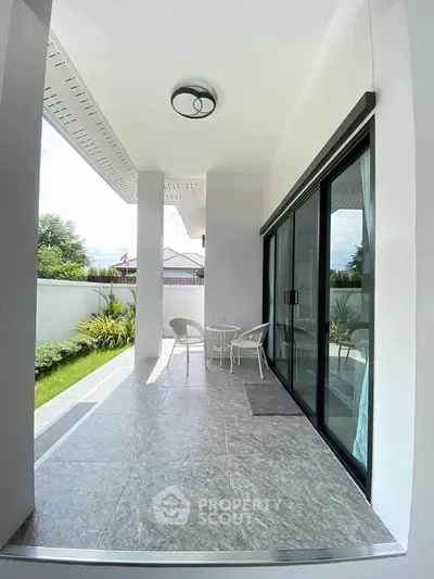 Modern patio with sleek design and garden view, perfect for relaxation and outdoor dining.