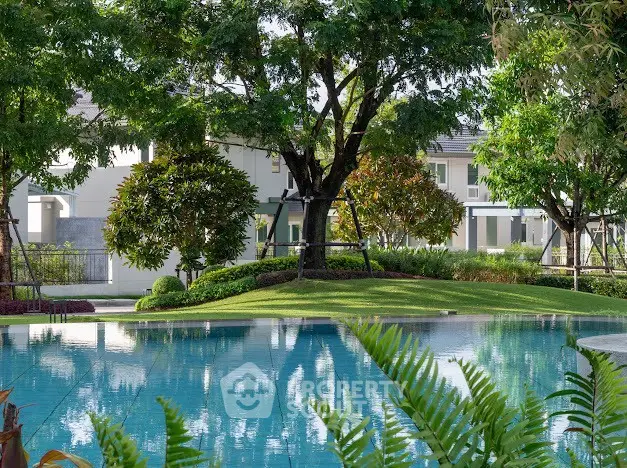 Luxurious residential pool surrounded by lush greenery and modern homes.