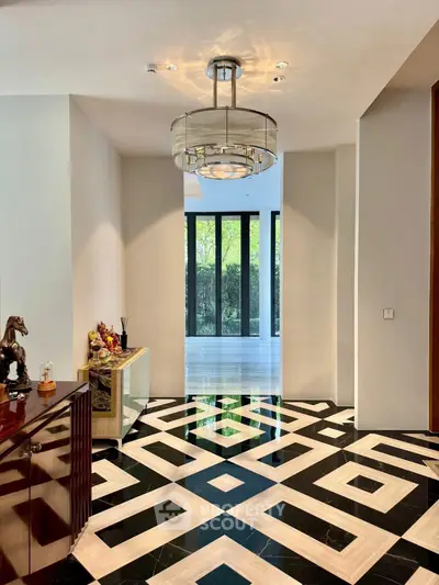Luxurious hallway with geometric floor tiles and elegant chandelier