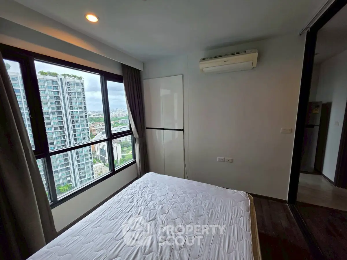 Modern bedroom with city view and air conditioning in high-rise apartment