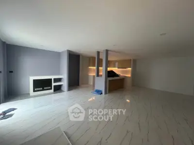 Spacious open-plan living room with modern kitchen and elegant flooring