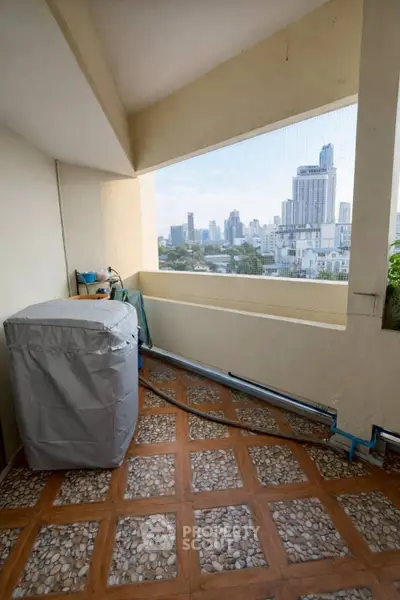 Spacious balcony with city skyline view, perfect for relaxation and enjoying urban living.