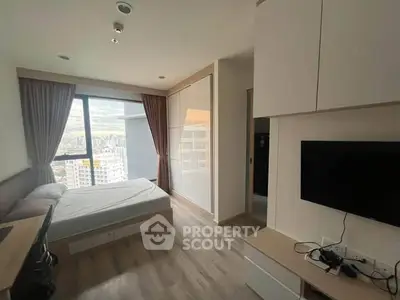 Modern bedroom with city view, featuring sleek furniture and large window for natural light.