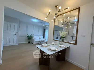 Modern open-plan living and dining area with stylish lighting and elegant decor.