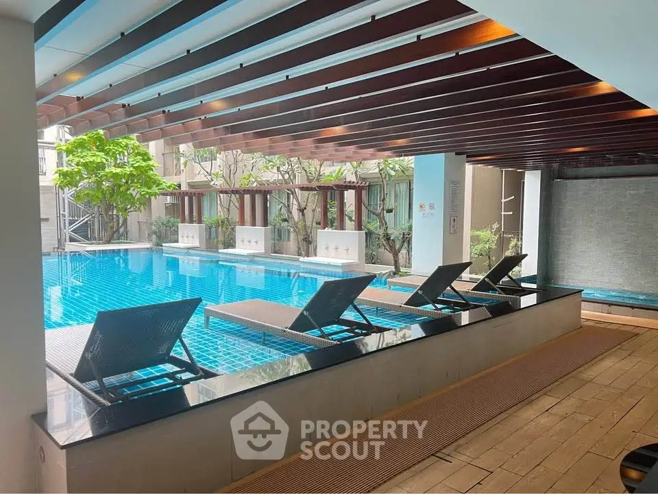 Luxurious indoor pool area with modern lounge chairs and elegant design