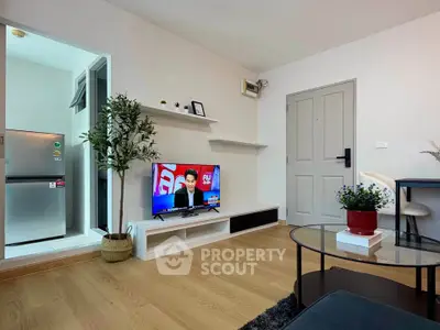 Modern living room with TV, open kitchen, and stylish decor