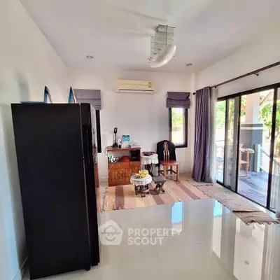 Spacious living room with modern decor and large sliding glass doors leading to a balcony.