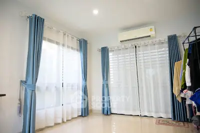 Bright room with blue curtains and air conditioning, perfect for modern living.
