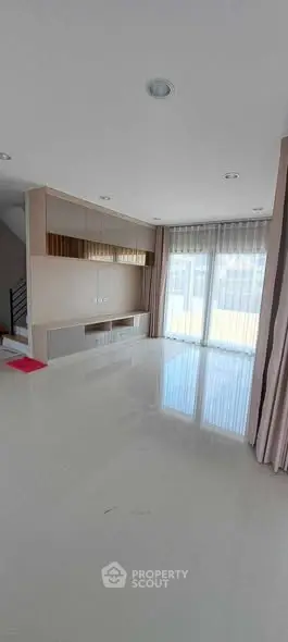 Spacious modern living room with large windows and built-in storage
