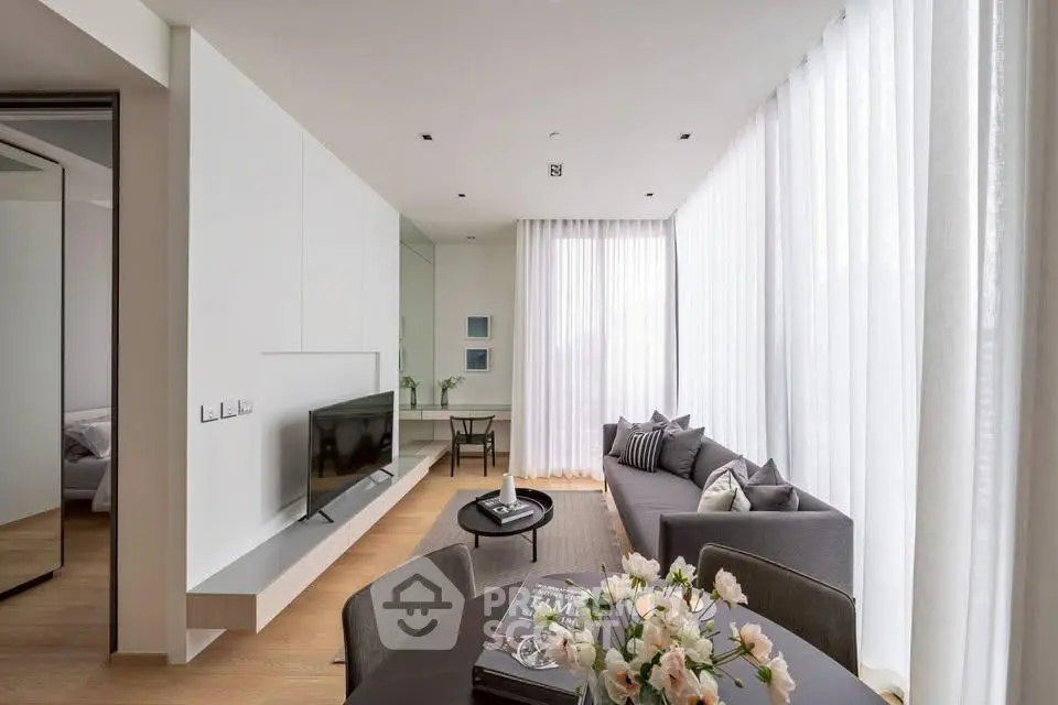 Modern living room with sleek design, large windows, and elegant decor in a contemporary apartment.