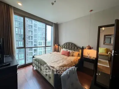 Luxurious bedroom with large windows offering stunning city views in a modern apartment.