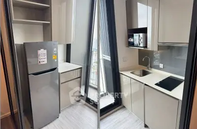 Modern kitchen with sleek cabinetry and stainless steel appliances in a high-rise apartment.