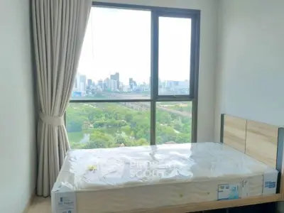 Bright bedroom with large window offering stunning city and park views.