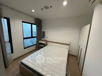 Modern bedroom with large window and minimalist furniture in high-rise apartment.