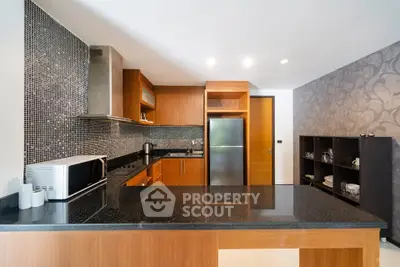Modern kitchen with sleek black countertops and wooden cabinetry