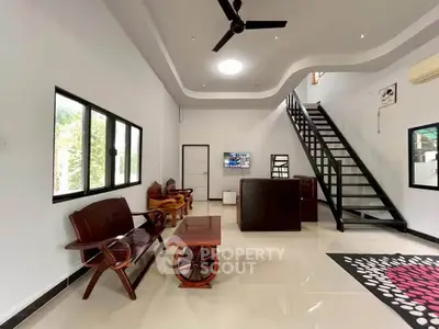 Spacious modern living room with high ceiling and stylish staircase