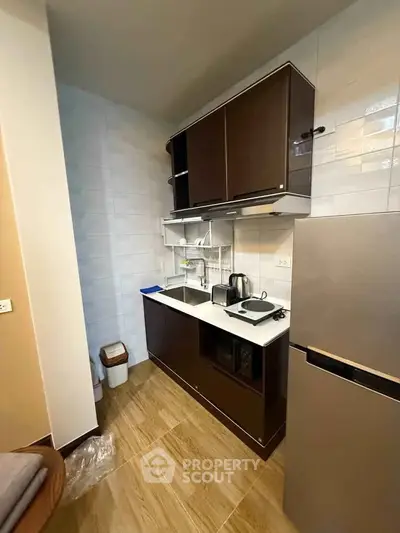Modern kitchen with sleek cabinets and appliances in a compact layout