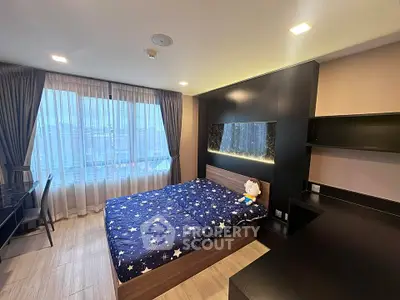 Modern bedroom with stylish decor and large window offering natural light.