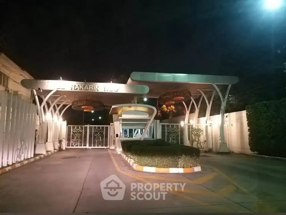 Elegant entrance of a modern residential building with stylish lighting and secure gated access.
