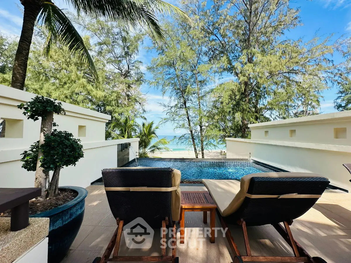 Luxurious beachfront pool area with stunning ocean view and palm trees.