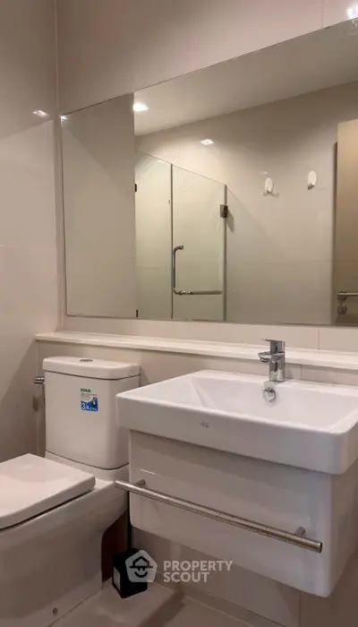 Modern bathroom with sleek fixtures and large mirror