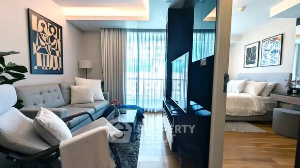 Modern living room with stylish decor and cozy bedroom in open layout apartment.