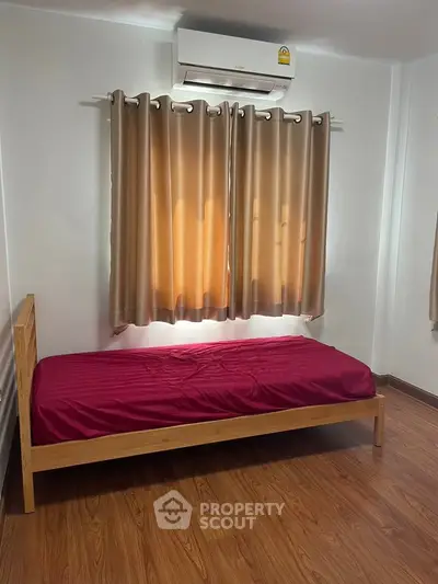 Cozy bedroom with single bed and air conditioning, perfect for a minimalist lifestyle.