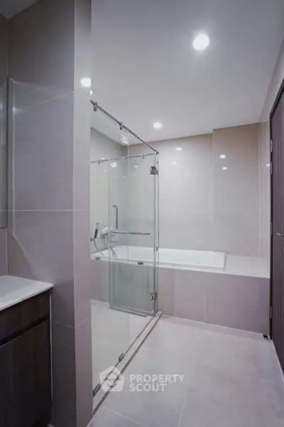 Modern bathroom with glass shower and bathtub in sleek design