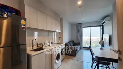 Modern apartment with open kitchen and living area, featuring a washing machine and city view balcony.