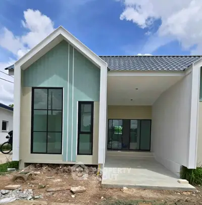 Modern single-story house with large windows and a sleek design under a clear blue sky.