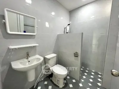 Modern bathroom with sleek fixtures and geometric tile flooring