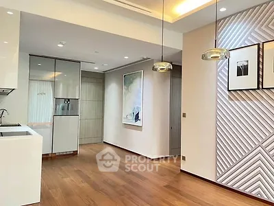 Modern open-layout kitchen with stylish lighting and wooden flooring in a contemporary apartment.