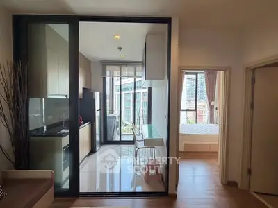 Modern apartment with sleek kitchen and cozy bedroom, featuring large windows and city views.