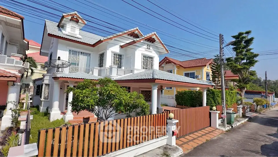 Charming two-story house with a fenced yard in a suburban neighborhood.