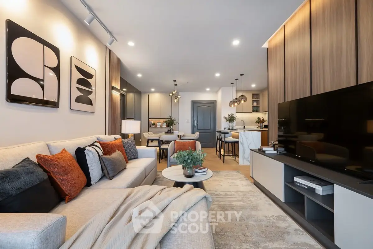 Modern living room with cozy seating and stylish decor in open-plan apartment.